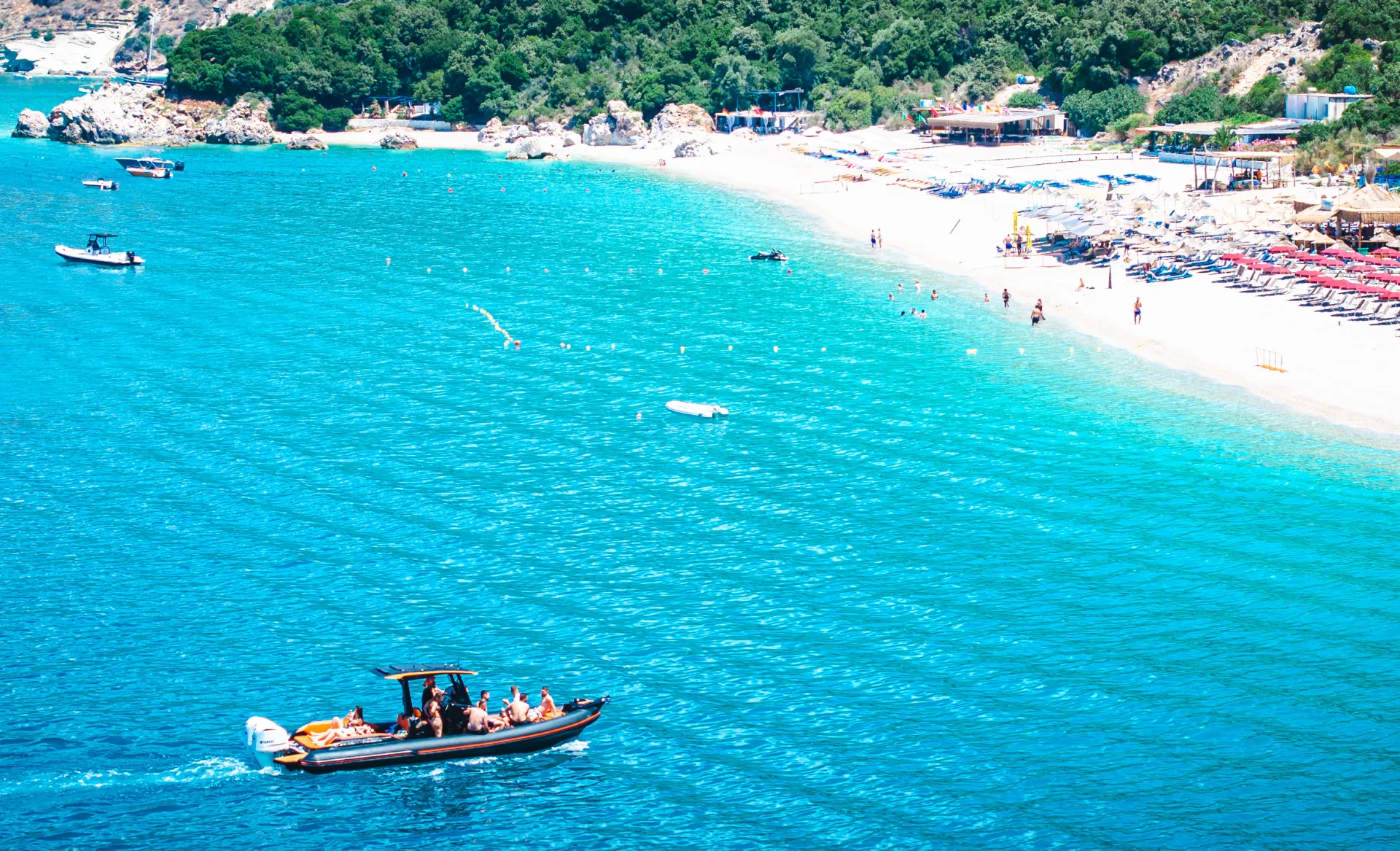 Aerial view of the Nemo Boat leaving a Saranda beach with guests on board