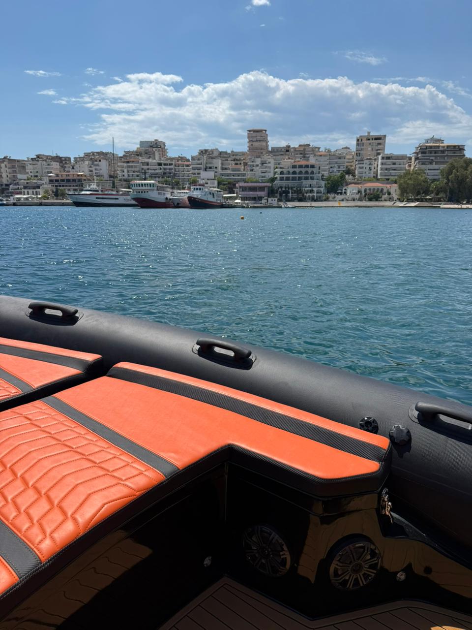 Black tube and orange quilted seating on the Nemo Boat with Saranda port and ferries in the background